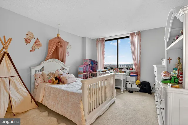 a spacious bedroom with a bed and a flat screen tv