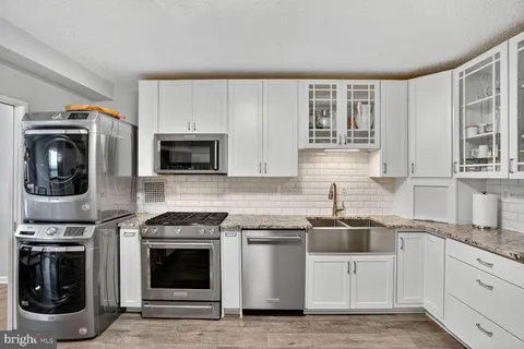 a kitchen with stainless steel appliances granite countertop a stove a sink and a microwave