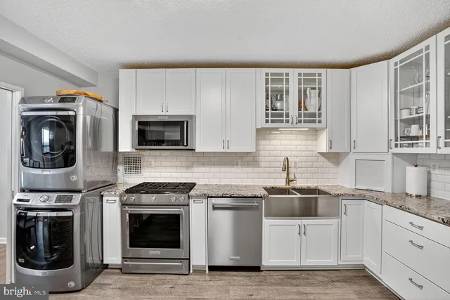a kitchen with stainless steel appliances granite countertop a stove a sink and a microwave