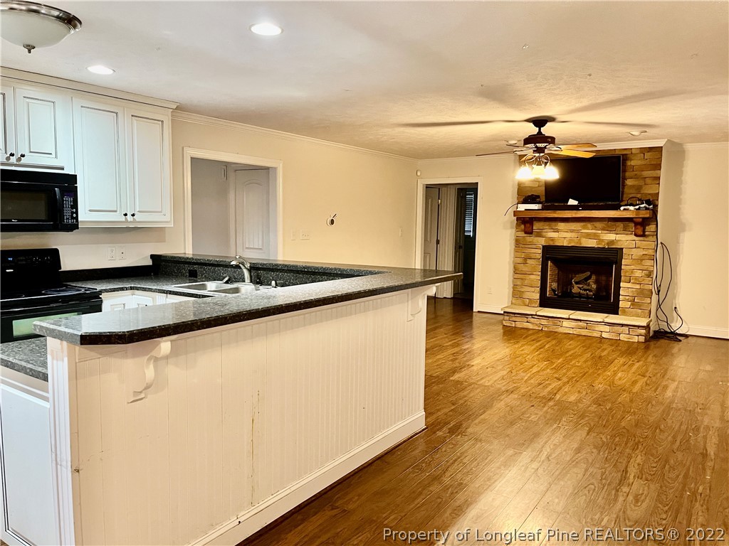 3140 Wade-Stedman Road Stedman, NC 28391 - Photo 12 of 36 a kitchen with granite countertop a sink cabinets and wooden floor