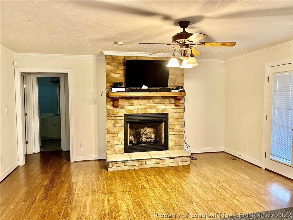 3140 Wade-Stedman Road Stedman, NC 28391 - Photo 16 of 36 a living room with a fireplace a flat screen tv and a fireplace