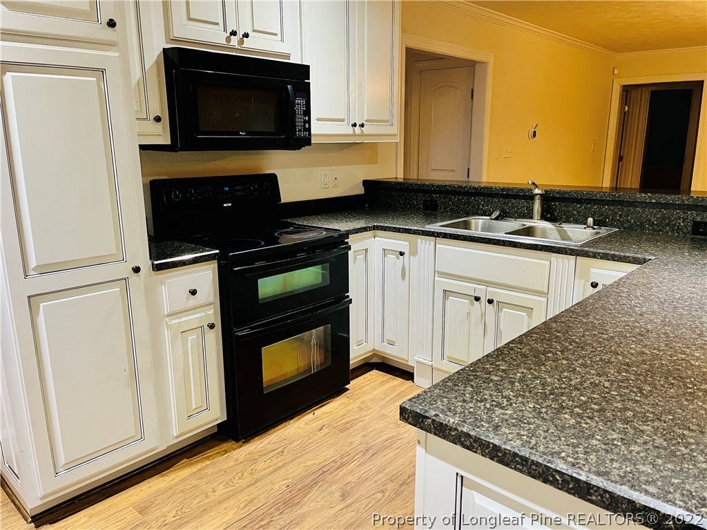 3140 Wade-Stedman Road Stedman, NC 28391 - Photo 6 of 36 a kitchen with stainless steel appliances granite countertop a stove microwave and sink