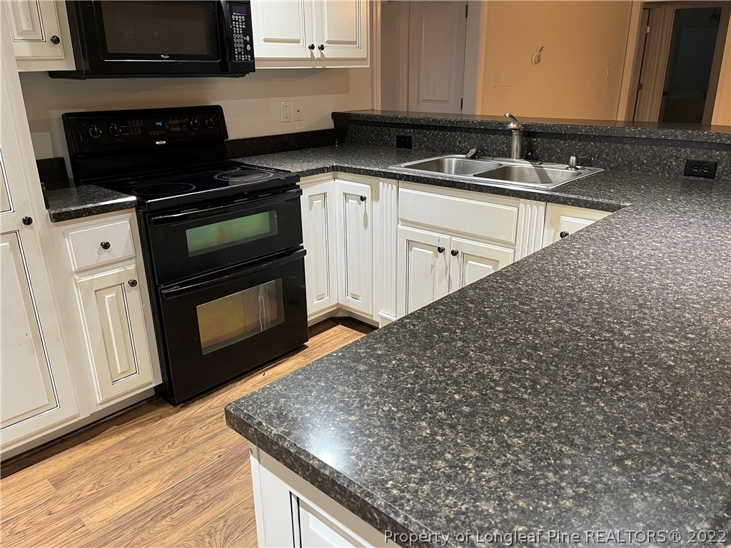 3140 Wade-Stedman Road Stedman, NC 28391 - Photo 7 of 36 a kitchen with stainless steel appliances granite countertop a stove a sink and a microwave