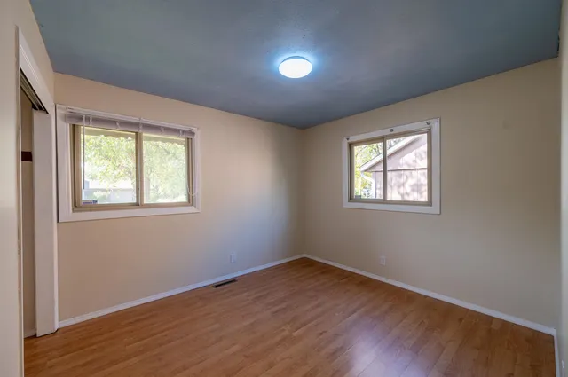 a view of empty room with wooden floor