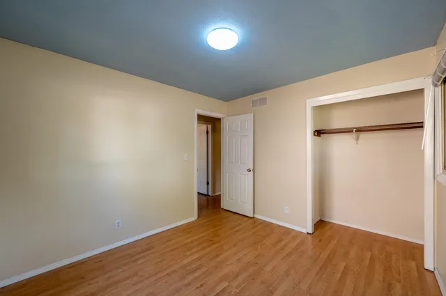 a view of an empty room with wooden floor