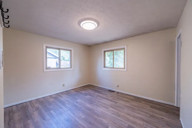a view of a room with wooden floor and windows
