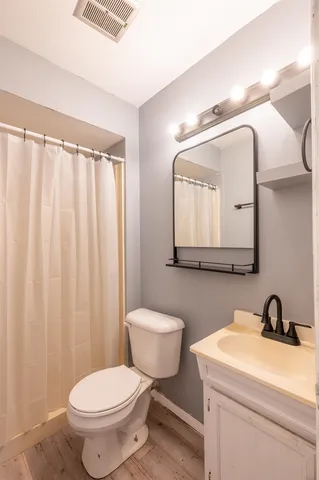a bathroom with a toilet a sink and mirror