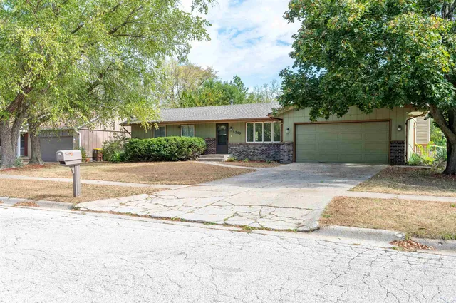a front view of a house with a yard and potted plants