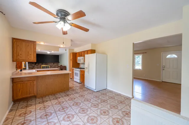 a view of a kitchen with wooden floor and a ceiling fan