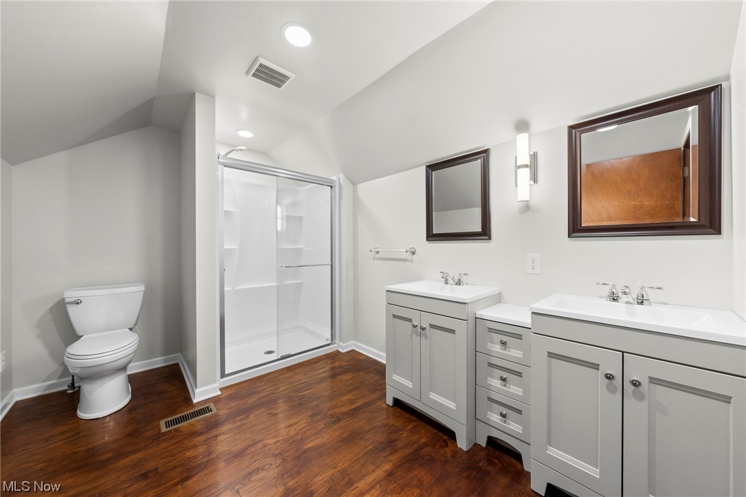 227 South Messner Road New Franklin, OH 44319 - Photo 39 of 44 Bathroom featuring an enclosed shower, hardwood / wood-style flooring, dual bowl vanity, toilet, and lofted ceiling