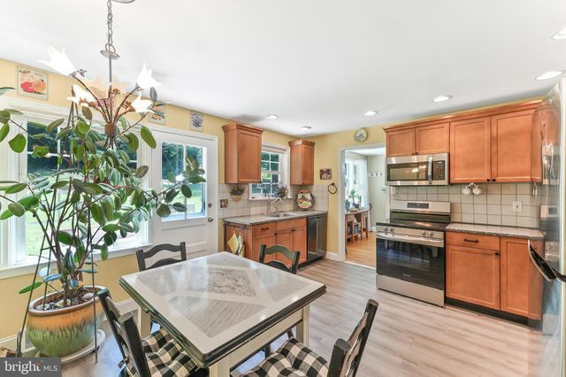 a open kitchen with stainless steel appliances granite countertop a stove a sink a refrigerator and a wooden cabinets