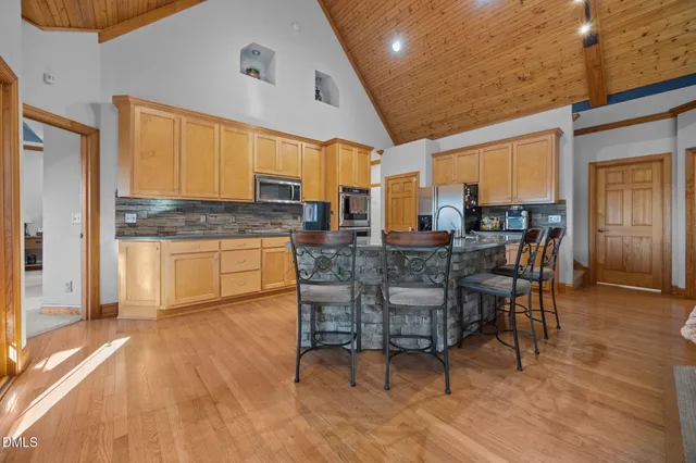 a dining hall with stainless steel appliances granite countertop a stove and a refrigerator