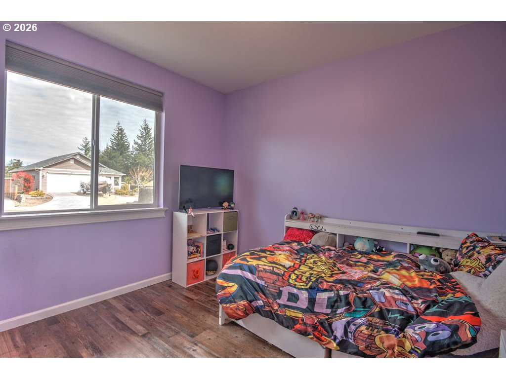 1966 34th Street Florence, OR 97439 - Photo 13 of 17 a bedroom with a bed and a flat screen tv