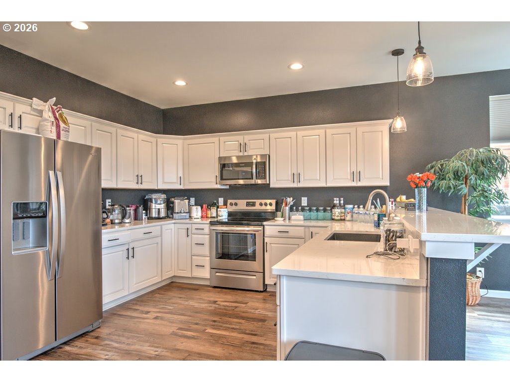 1966 34th Street Florence, OR 97439 - Photo 3 of 17 a kitchen with white cabinets and stainless steel appliances