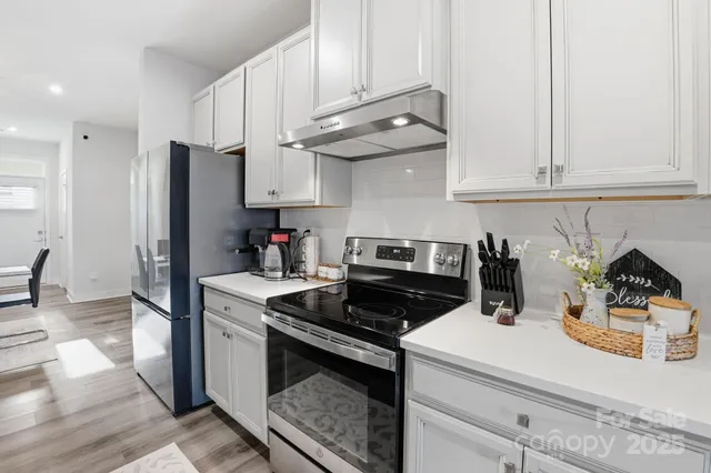 a kitchen with a table chairs microwave and cabinets