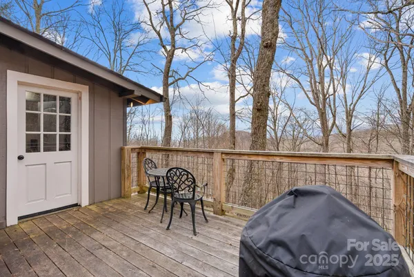 a roof deck with table and chairs and wooden floor