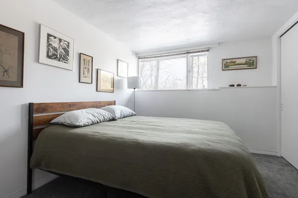 a bedroom with a bed and painting on the wall