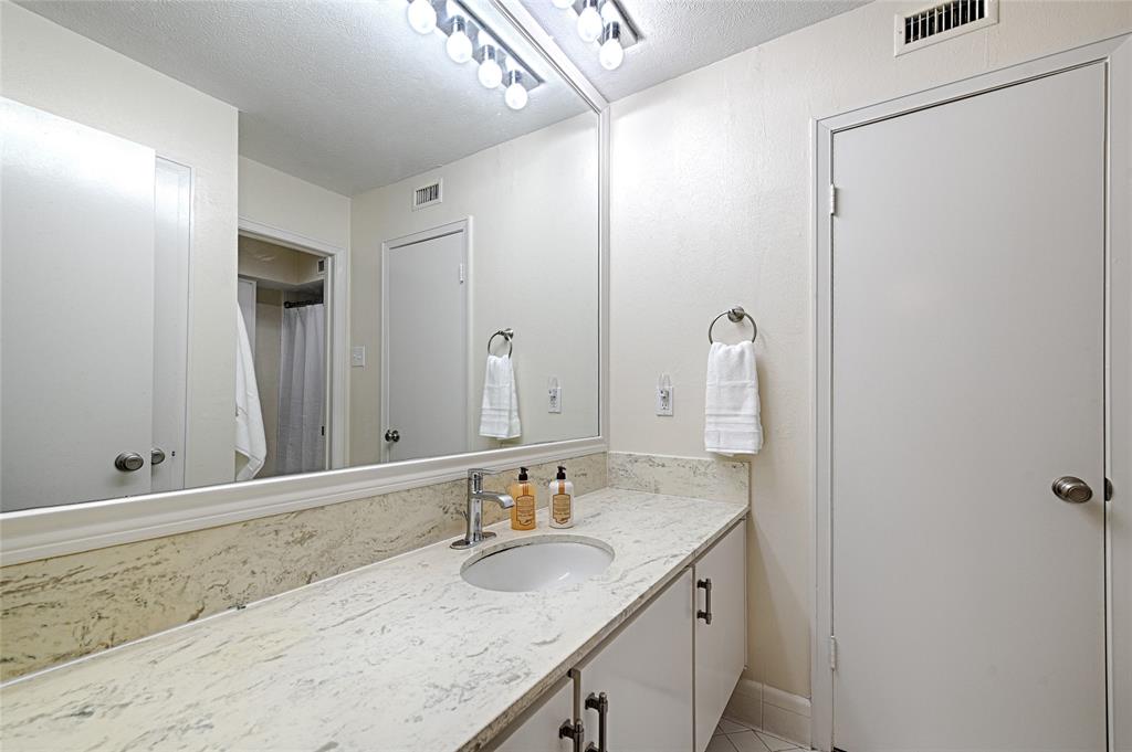 10757 Villager Road, Unit D Dallas, TX 75230 - Photo 14 of 21 a bathroom with a granite countertop sink and a mirror