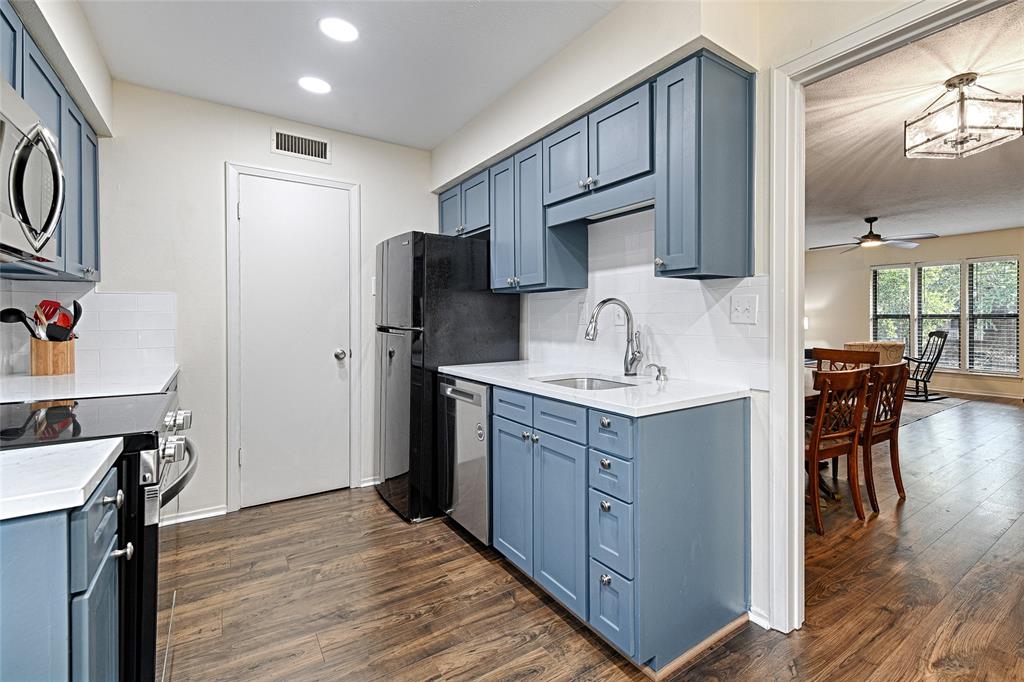 10757 Villager Road, Unit D Dallas, TX 75230 - Photo 9 of 21 a kitchen with stainless steel appliances a sink cabinets and wooden floor