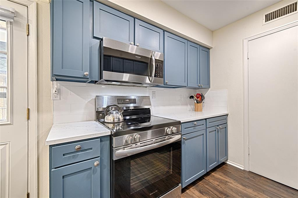 10757 Villager Road, Unit D Dallas, TX 75230 - Photo 10 of 21 a kitchen with stainless steel appliances granite countertop a sink stove and microwave