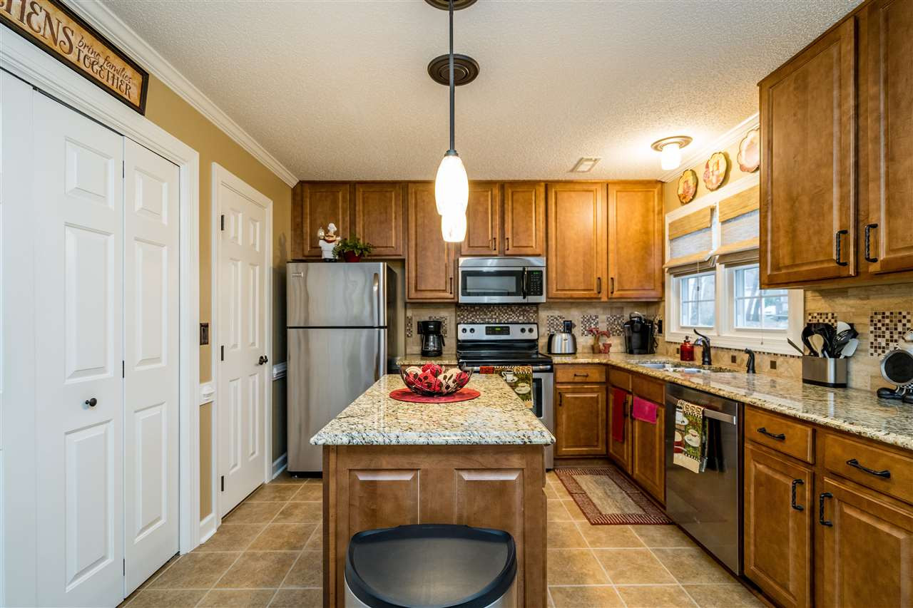 5213 Denmead Way Raleigh, NC 27613 - Photo 11 of 25 a kitchen with stainless steel appliances granite countertop a sink stove and refrigerator