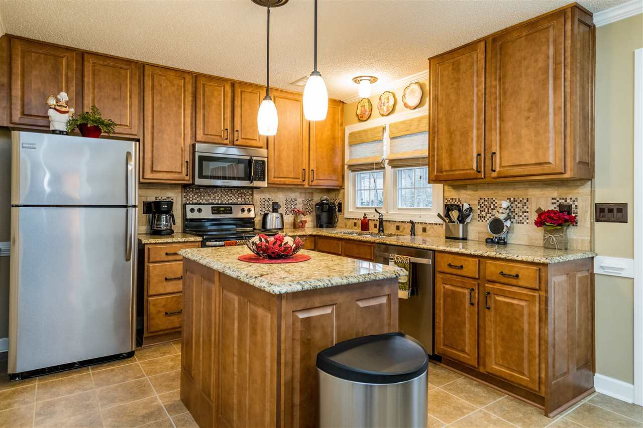 5213 Denmead Way Raleigh, NC 27613 - Photo 12 of 25 a kitchen with stainless steel appliances granite countertop a refrigerator a stove a sink and a cabinets
