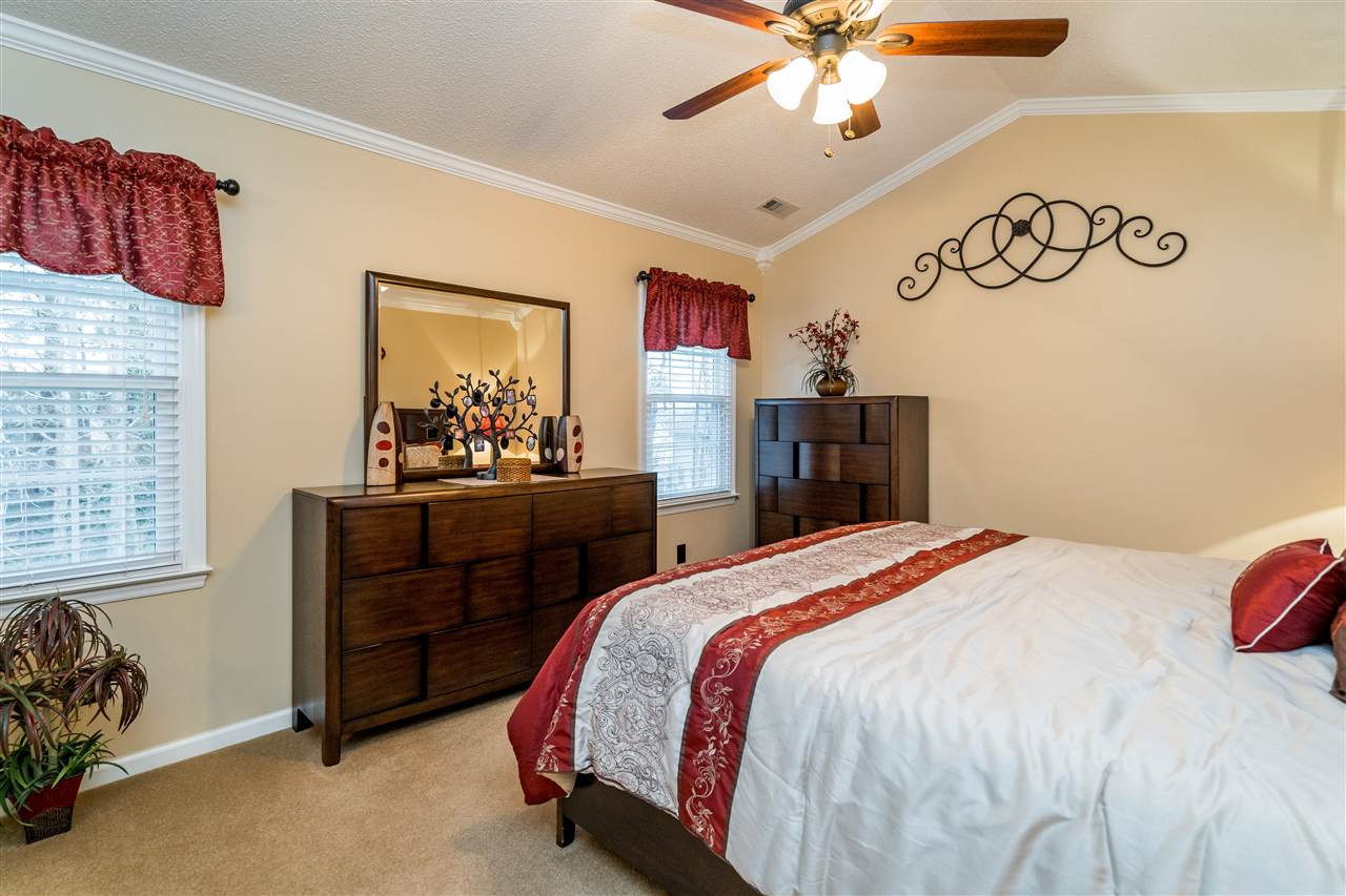 5213 Denmead Way Raleigh, NC 27613 - Photo 17 of 25 a bedroom with a bed and a chandelier