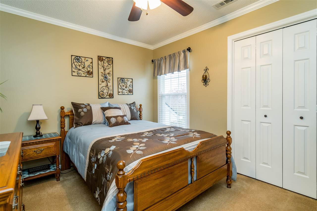 5213 Denmead Way Raleigh, NC 27613 - Photo 20 of 25 a spacious bedroom with a bed and a chandelier