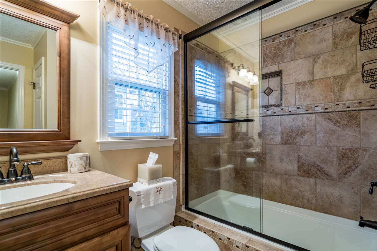 5213 Denmead Way Raleigh, NC 27613 - Photo 21 of 25 a bathroom with a granite countertop sink toilet a mirror and shower