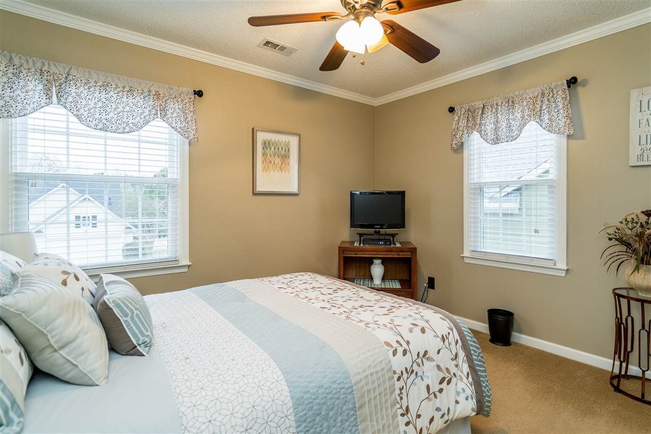 5213 Denmead Way Raleigh, NC 27613 - Photo 22 of 25 a bedroom with a bed and a flat tv screen on dresser