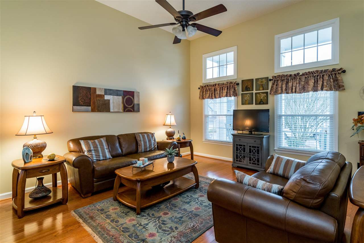 5213 Denmead Way Raleigh, NC 27613 - Photo 4 of 25 a living room with furniture a flat screen tv and a fireplace