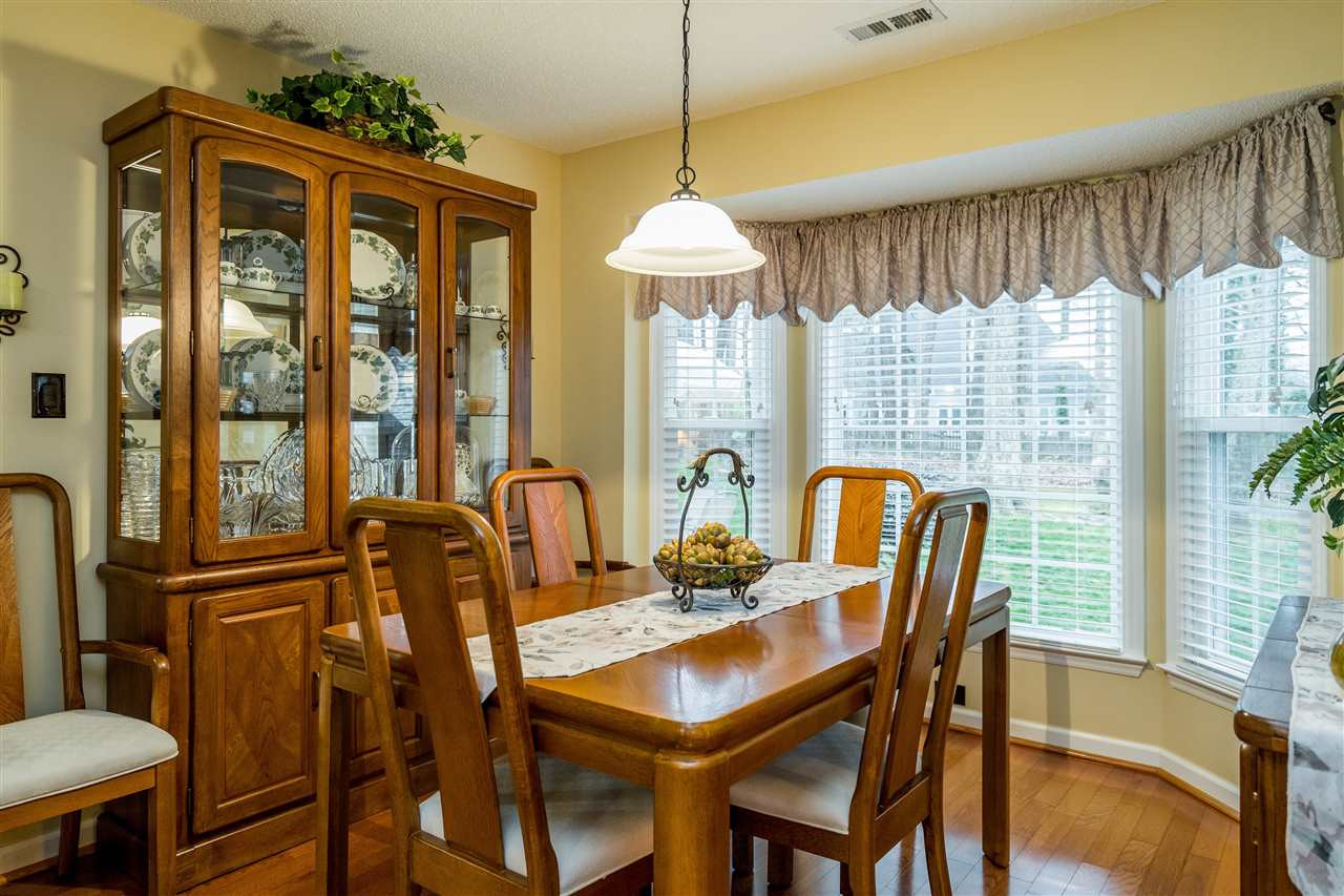 5213 Denmead Way Raleigh, NC 27613 - Photo 8 of 25 a dining room with furniture a chandelier and wooden floor