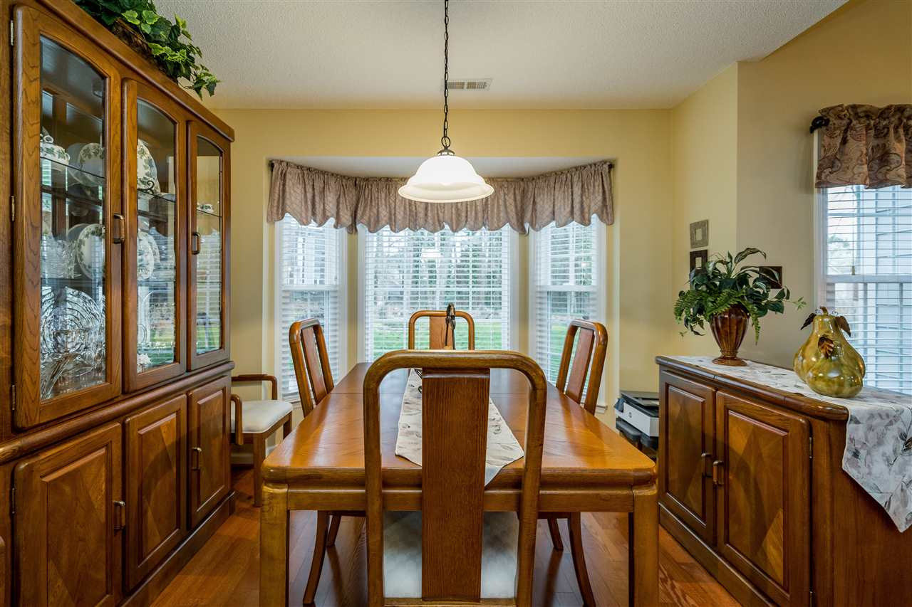 5213 Denmead Way Raleigh, NC 27613 - Photo 9 of 25 a dining room with furniture potted plants and wooden floor