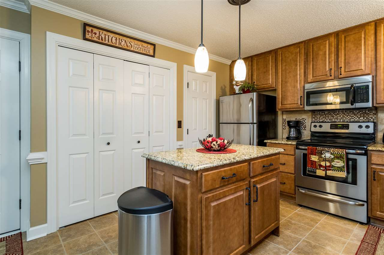 5213 Denmead Way Raleigh, NC 27613 - Photo 10 of 25 a kitchen with stainless steel appliances granite countertop a stove refrigerator and cabinets
