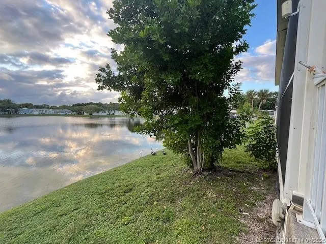a view of a room with wooden floor fan and windows