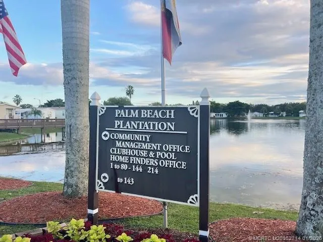 a view of an empty room with wooden floor fireplace and a window