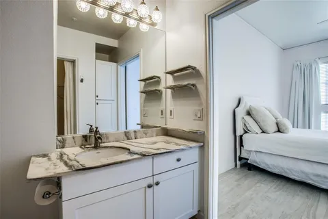 a en suite bathroom with a granite countertop sink and a mirror