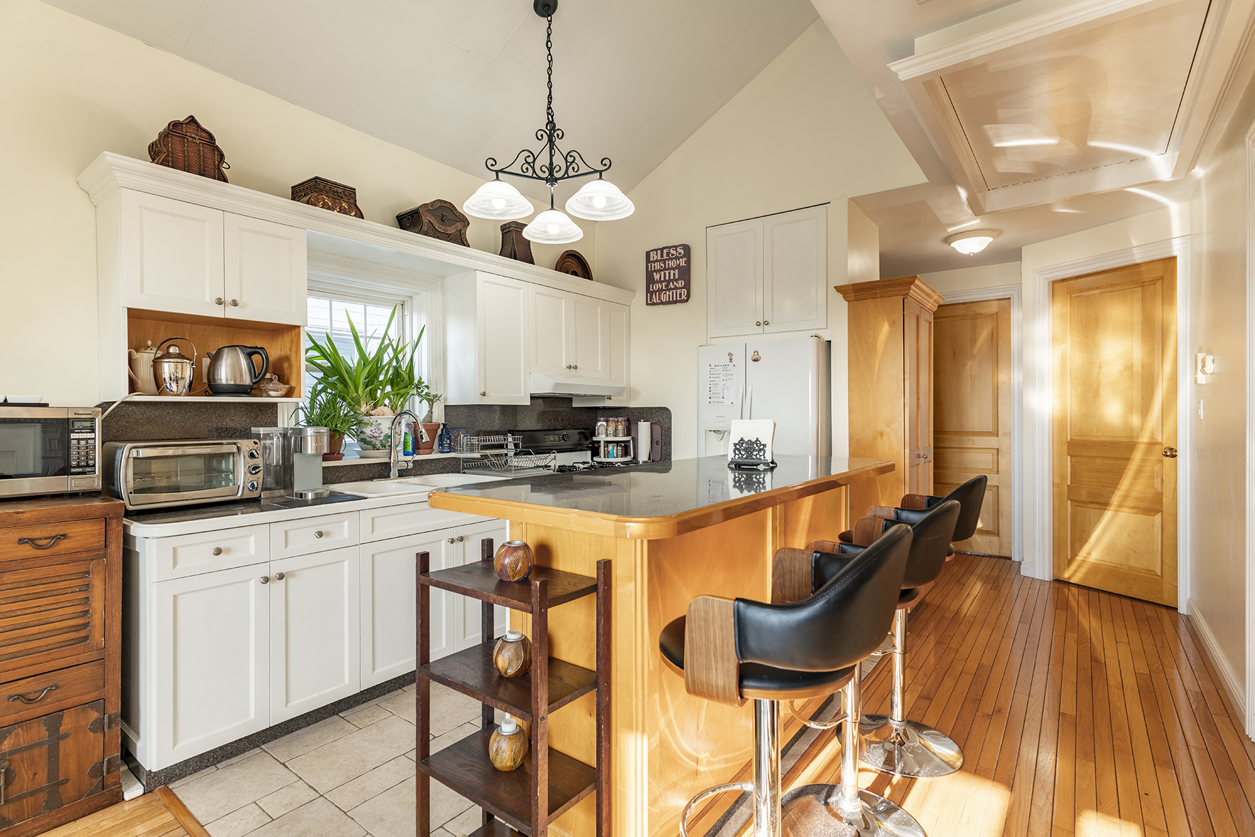 68-23 Exeter Street, Unit 2 Queens, NY 11375 - Photo 5 of 15 a kitchen with stainless steel appliances kitchen island granite countertop a table chairs in it and wooden floors