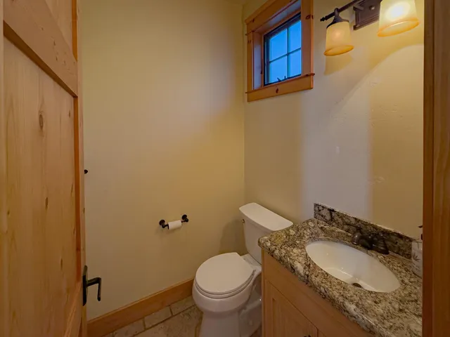 a bathroom with a granite countertop toilet and a sink