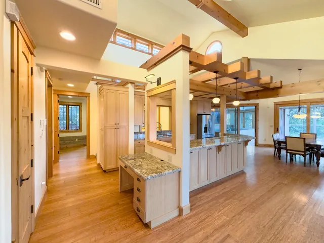 a view of living room with kitchen island granite countertop wooden floor and stainless steel appliances