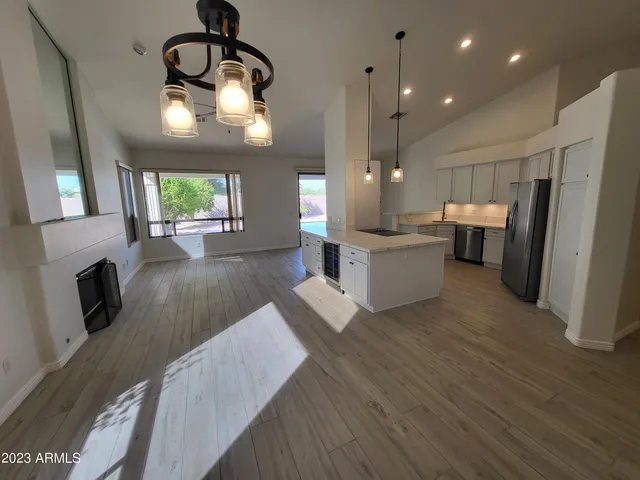 a view of a kitchen with a sink and dishwasher a refrigerator with wooden floor