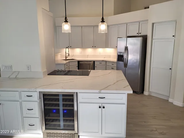 a kitchen with kitchen island a counter top a refrigerator and cabinets