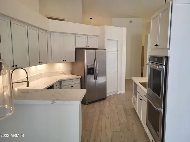 a kitchen with stainless steel appliances a refrigerator sink and cabinets