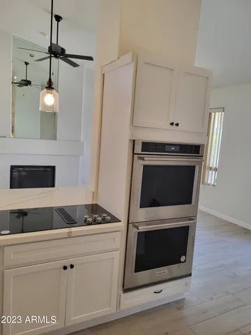 a kitchen with white cabinets and appliances