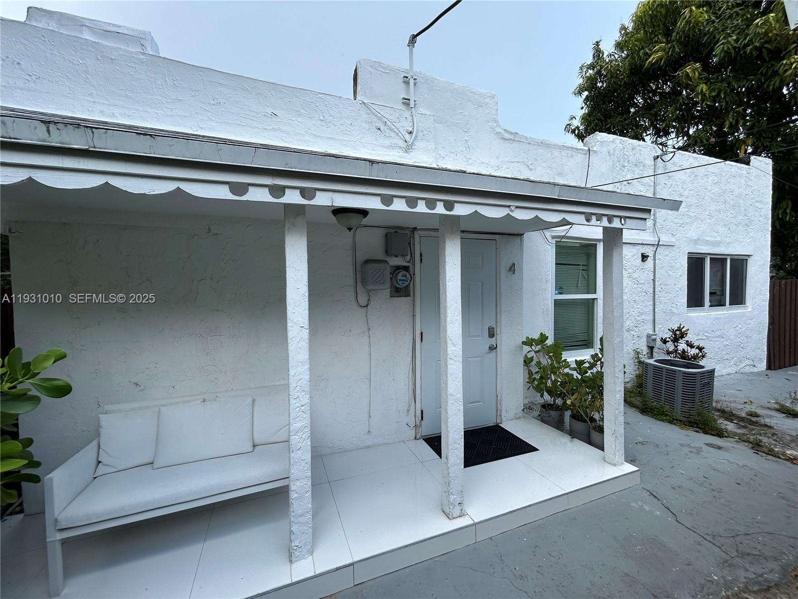 551 Northwest 41st Street, Unit 4 Miami, FL 33127 - Photo 2 of 13 a hallway with a glass door and furniture
