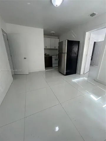 a view of kitchen with refrigerator and microwave