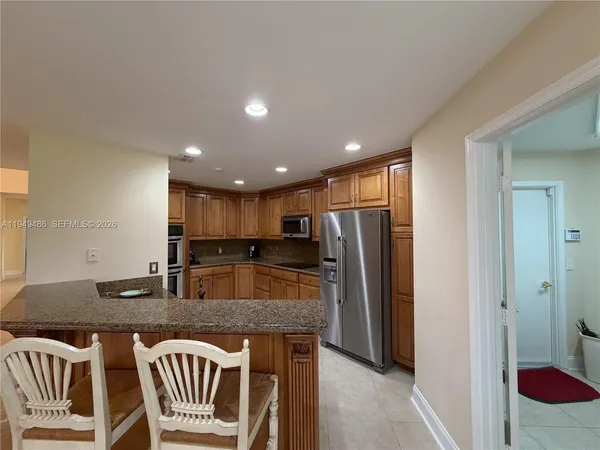 a kitchen with a refrigerator and a stove top oven