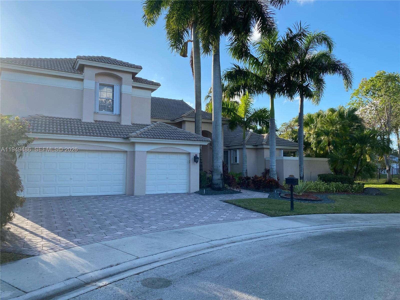 3279 Huntington Weston, FL 33332 - Photo 2 of 40 a front view of house with small garden and palm tree