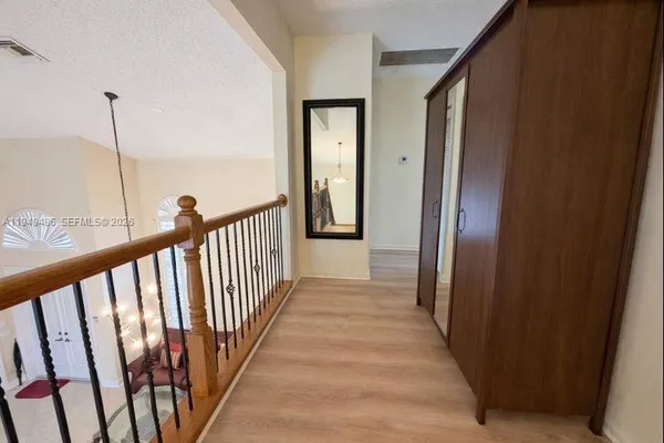 a view of a hallway with wooden floor and stairs