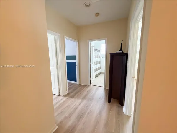 a view of a room with wooden floor and a refrigerator